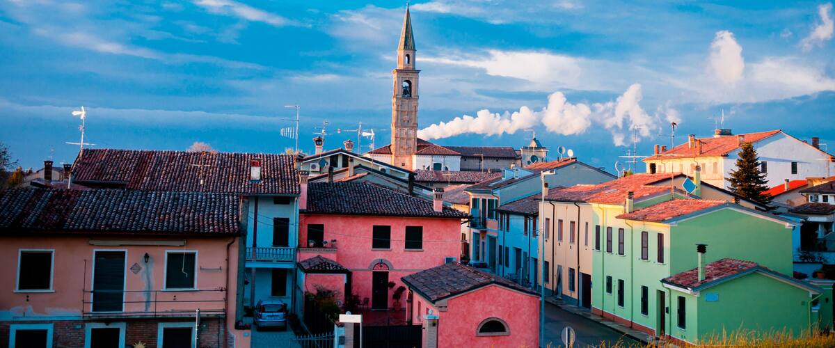 A coastal town with colorful buildings and a prominent church tower.