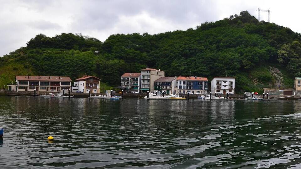 A river with boats, a bridge, and buildings along the banks.