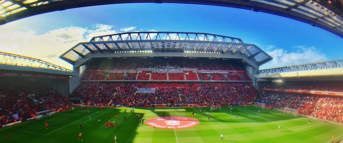 Panorama of Anfield stadium, taken from the Centenary Stand, showing from left to right: The Kop, the new Main Stand and the Anfield Road Stand