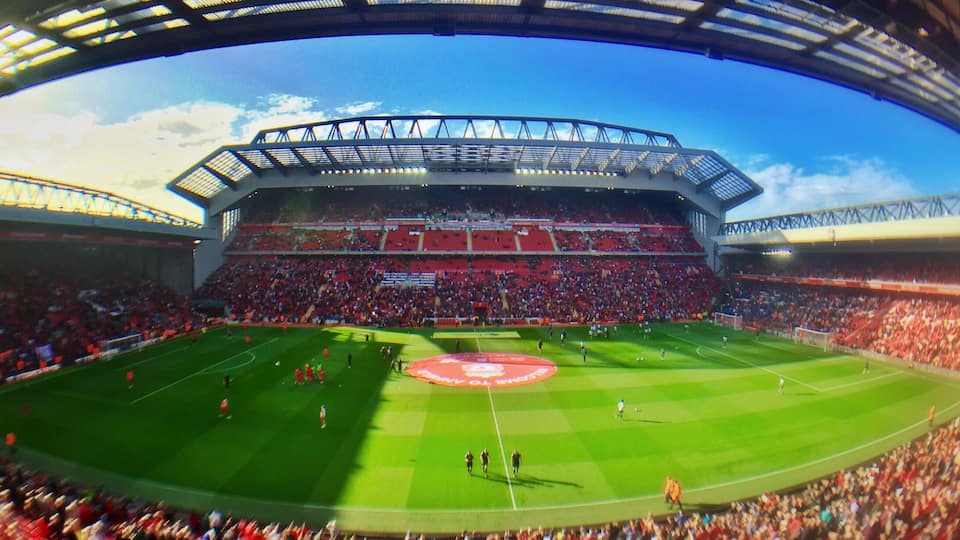 Panorama of Anfield stadium, taken from the Centenary Stand, showing from left to right: The Kop, the new Main Stand and the Anfield Road Stand