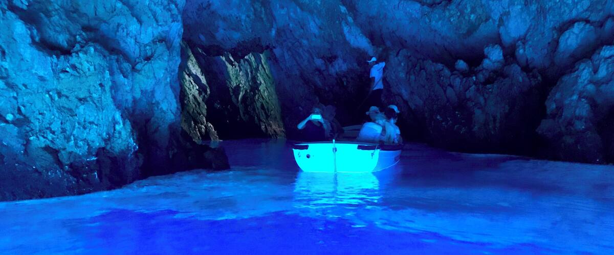 A cave with a boat in the water.