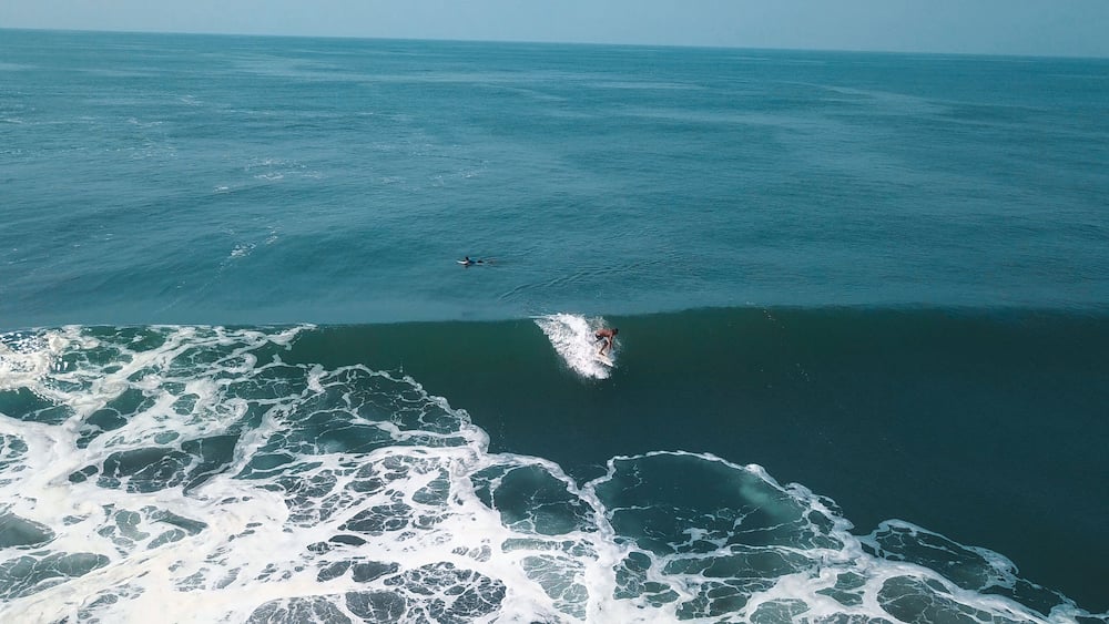 Mesmerizing shot of a surfer at the top of the wave in El Paredon beach in Monterrico, Guatemala