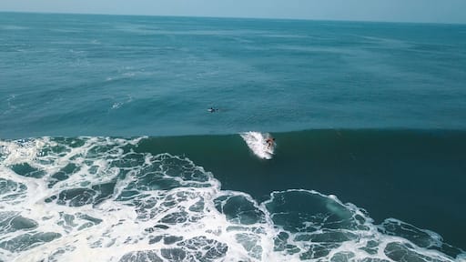 Mesmerizing shot of a surfer at the top of the wave in El Paredon beach in Monterrico, Guatemala
