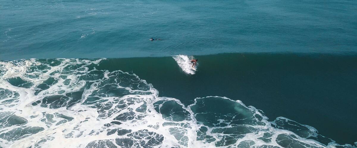 A surfer riding a wave in the ocean.