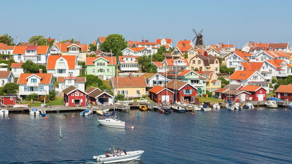 A coastal village with colorful houses and a windmill.