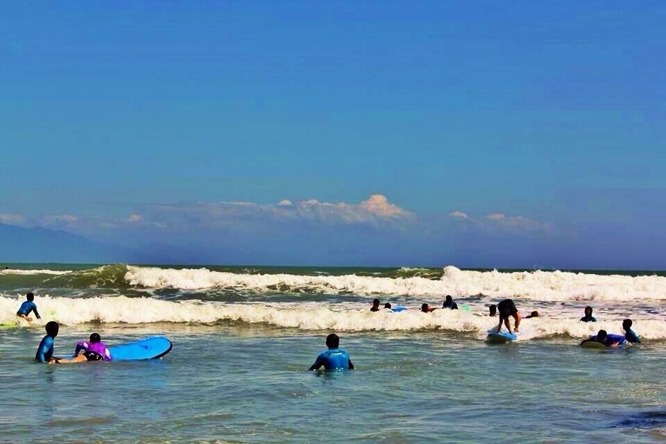 A beach with surfers and swimmers in the water.