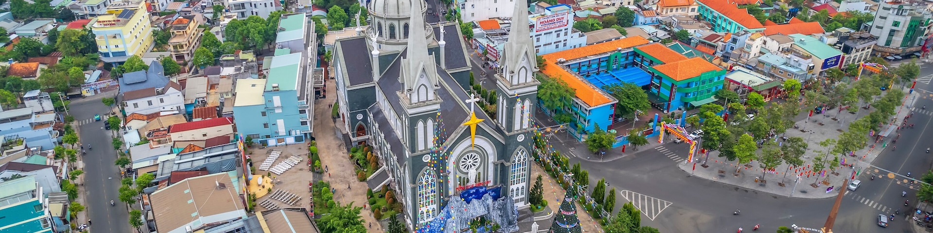 Aerial view of Thu Dau Mot cityscape at morning with church on hill in center. Urban development texture, transport infrastructure and green parks along Be River in Southeast region of Vietnam