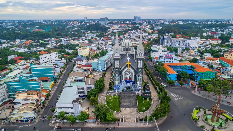 A cathedral with a star on top, surrounded by a cityscape with various buildings and a roundabout.