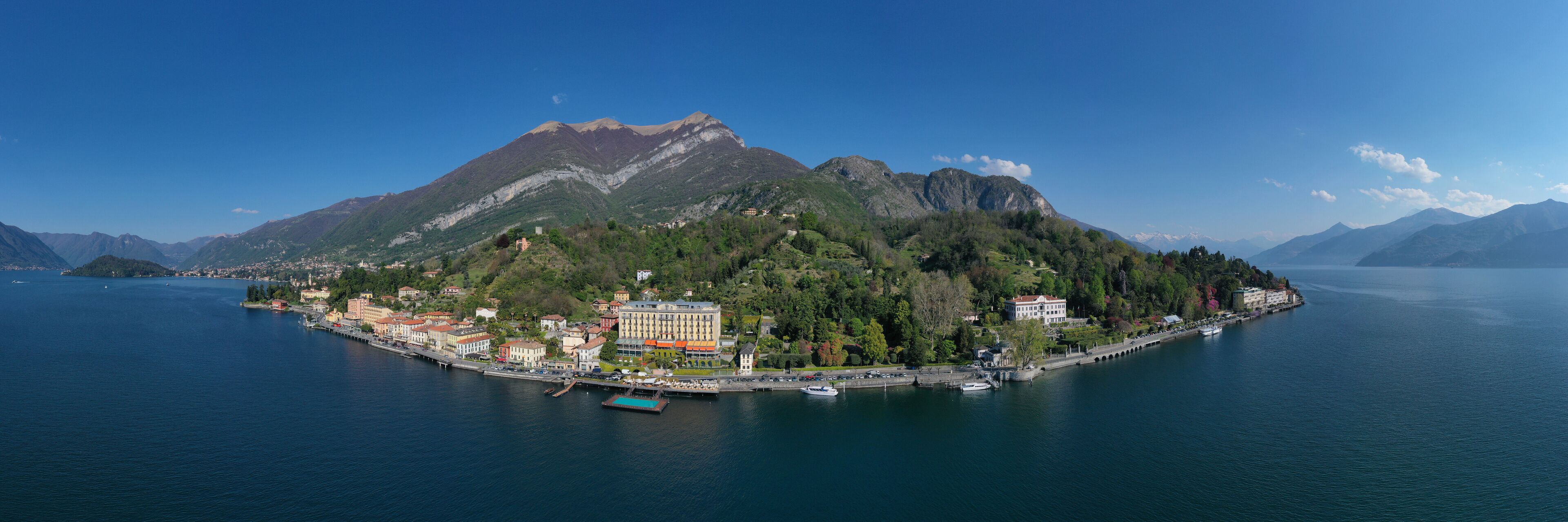 A coastal town with a prominent mountain in the background, a marina with boats, and a mix of residential and commercial buildings.