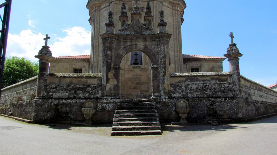 A historic church with a central dome, flanked by two bell towers, and a set of stairs leading to the entrance.