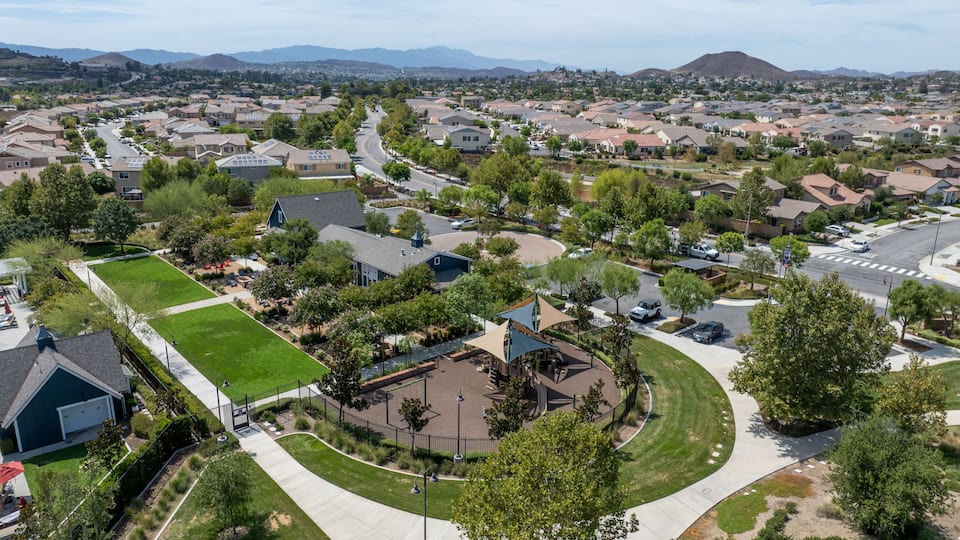 A suburban neighborhood with houses, green spaces, and a central park area.