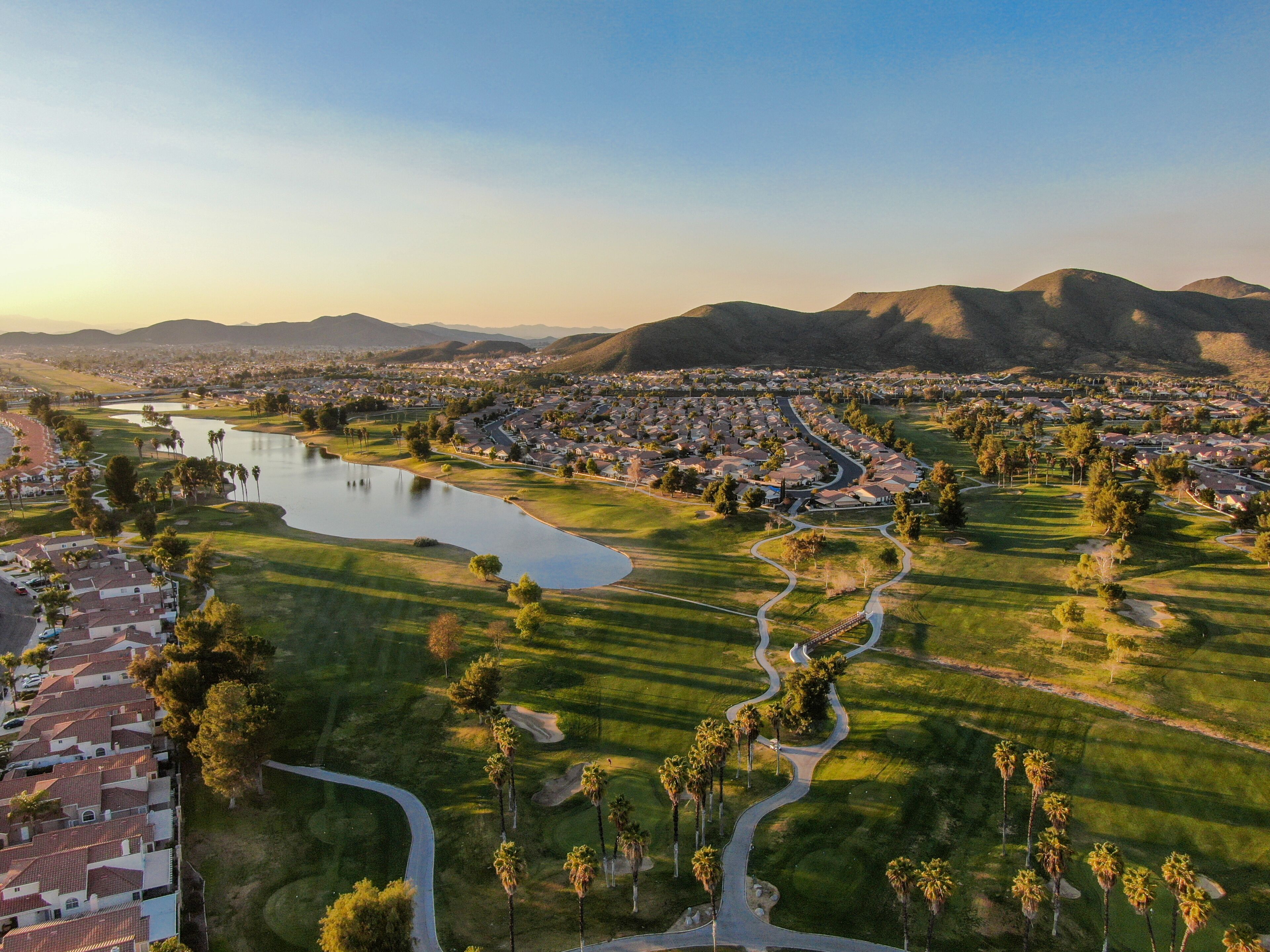 Aerial view of golf course surrounded by town houses and luxury villas during sunset time. Temecula, California, USA