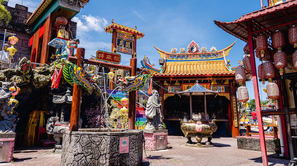 A traditional Chinese temple with ornate architecture, including a dragon statue and a large lion statue.
