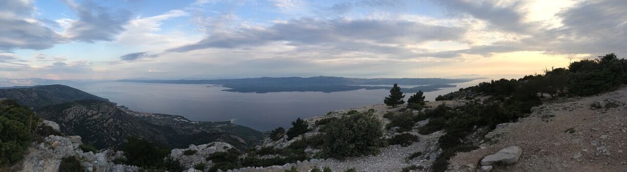 A mountainous landscape with a lake and distant landforms.