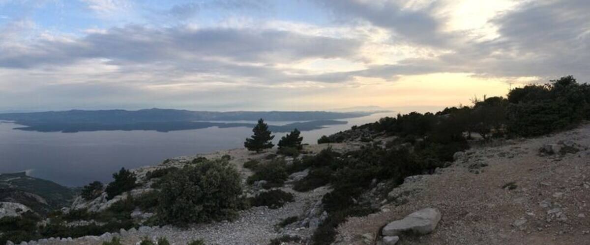 A mountainous landscape with a lake and distant landforms.