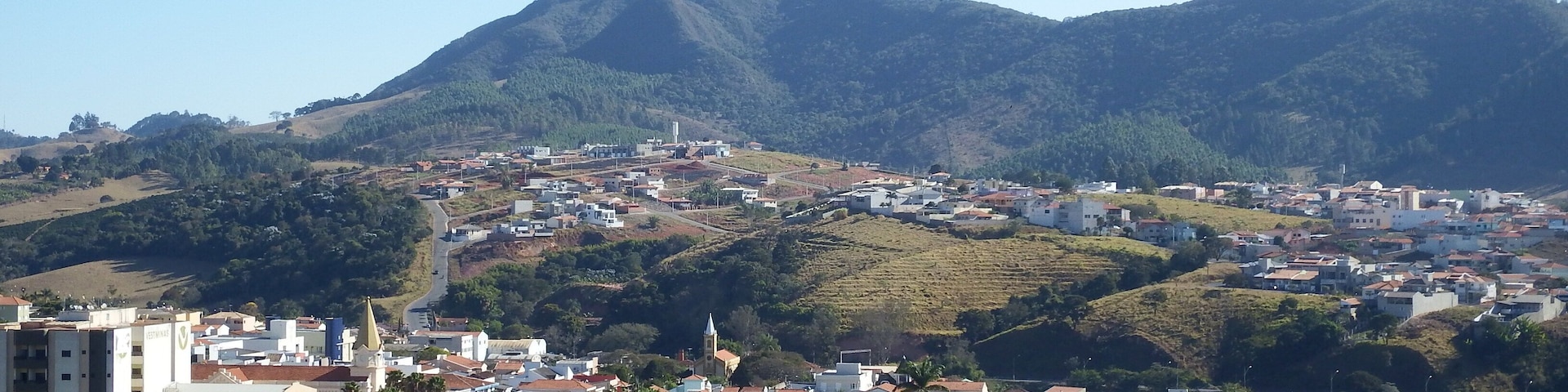 A town nestled in a valley with a prominent mountain in the background.