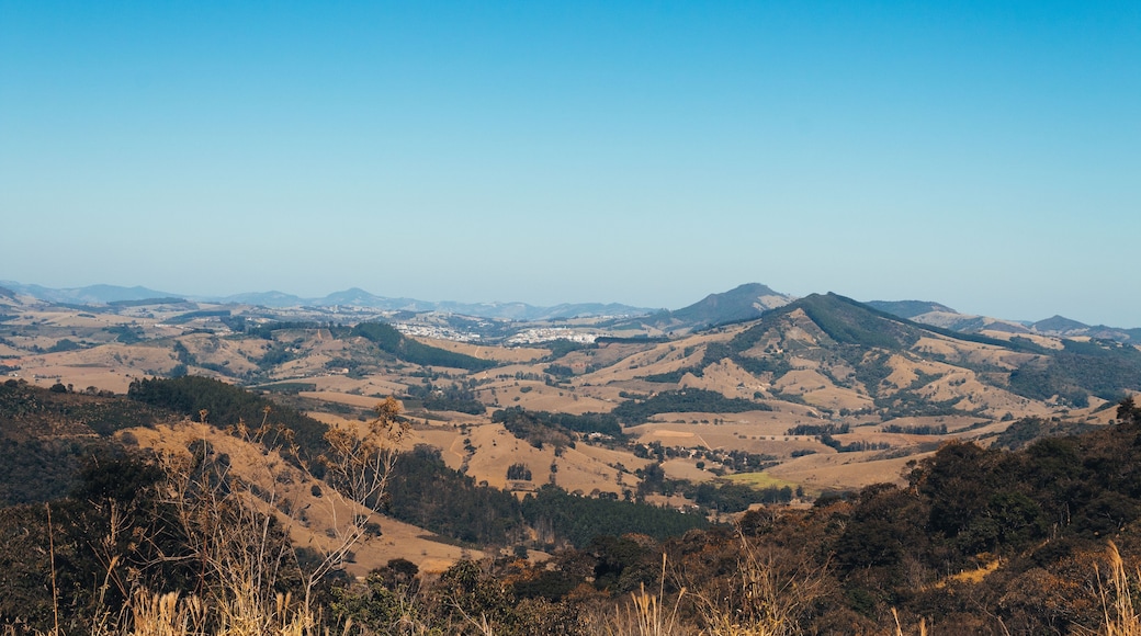 A panoramic view of a hilly landscape with a clear blue sky.