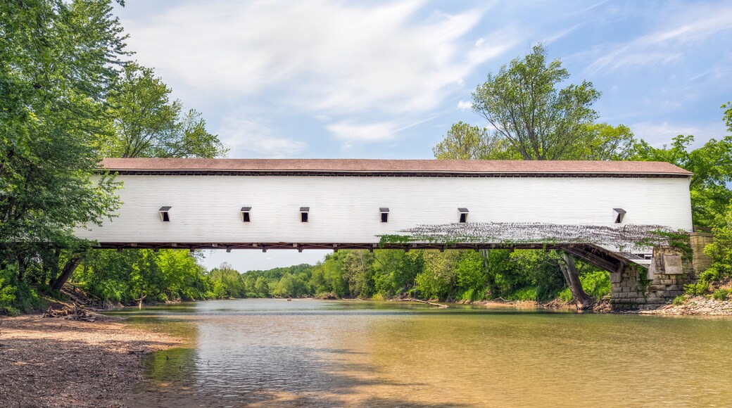 The white single span Jackson Covered Bridge crosses Sugar Creek in rural Parke County, Indiana