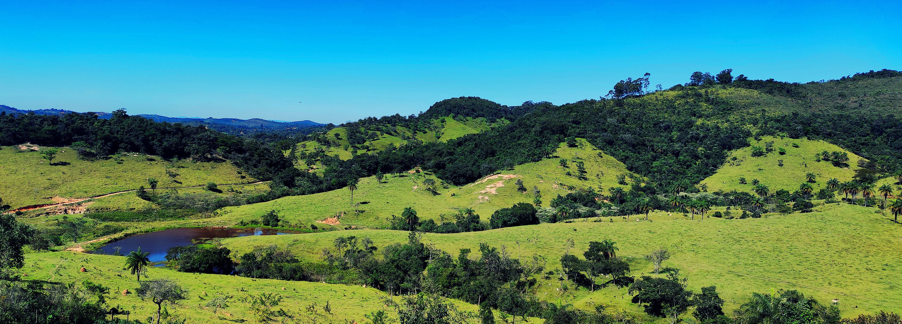 Linda vista de cima de montanha em final de tarde ensolarada, de fazenda situada na região de Esmeraldas, Minas Gerais, Brasil.