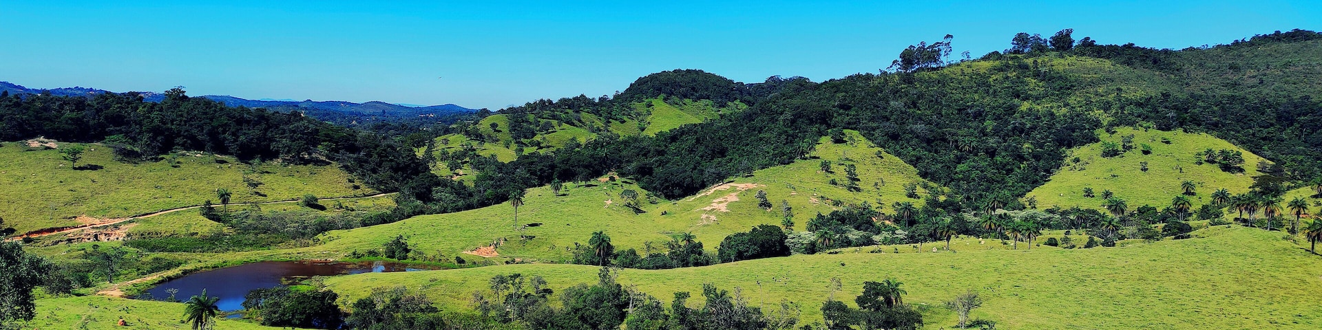 Linda vista de cima de montanha em final de tarde ensolarada, de fazenda situada na região de Esmeraldas, Minas Gerais, Brasil.