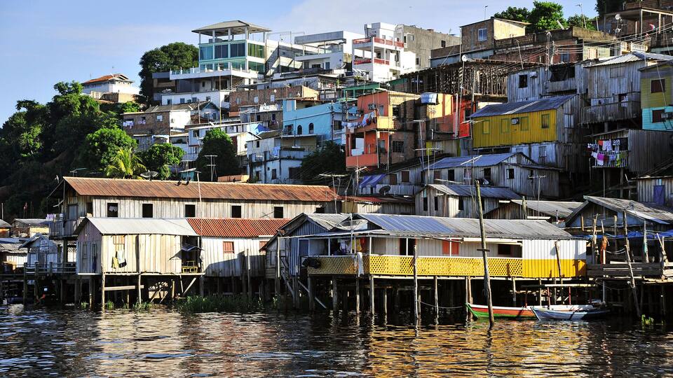 A riverside settlement with colorful houses built on stilts.