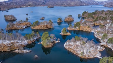 Ein See, umgeben von Bergen und kleinen Inseln mit spärlicher Vegetation.