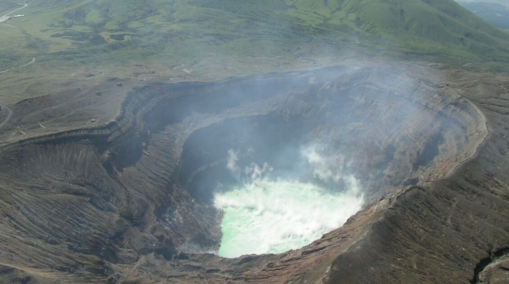 Mount Aso acid lake (crater of Mount Naka) seen from helicopter. Green mountains in the background, in the NW direction, are Mounts Kijima (left) and Ojo (right). Aso caldera walls are also visible further back. The picture points to the NW direction.