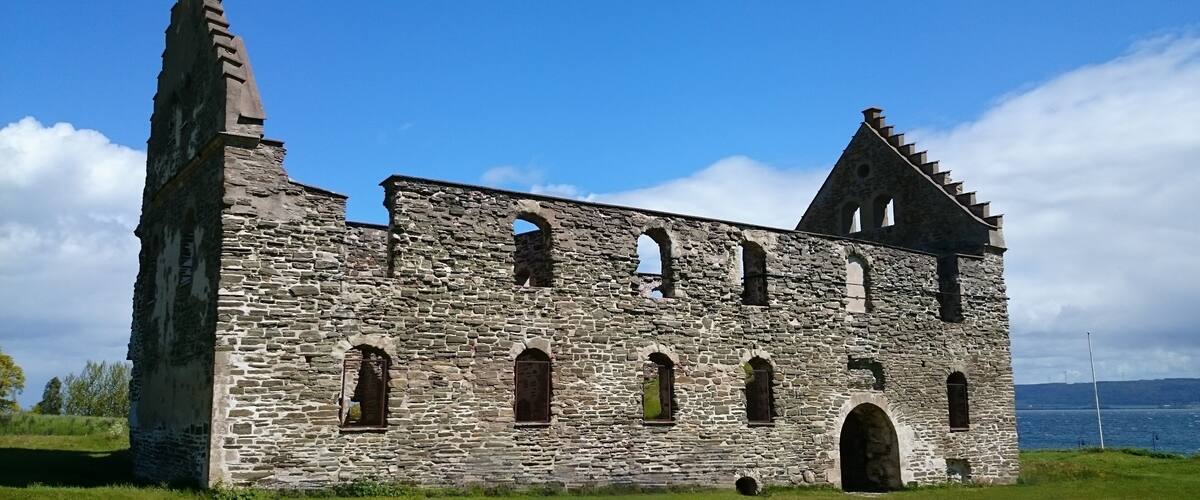 A stone church with arched windows and a steep tower.