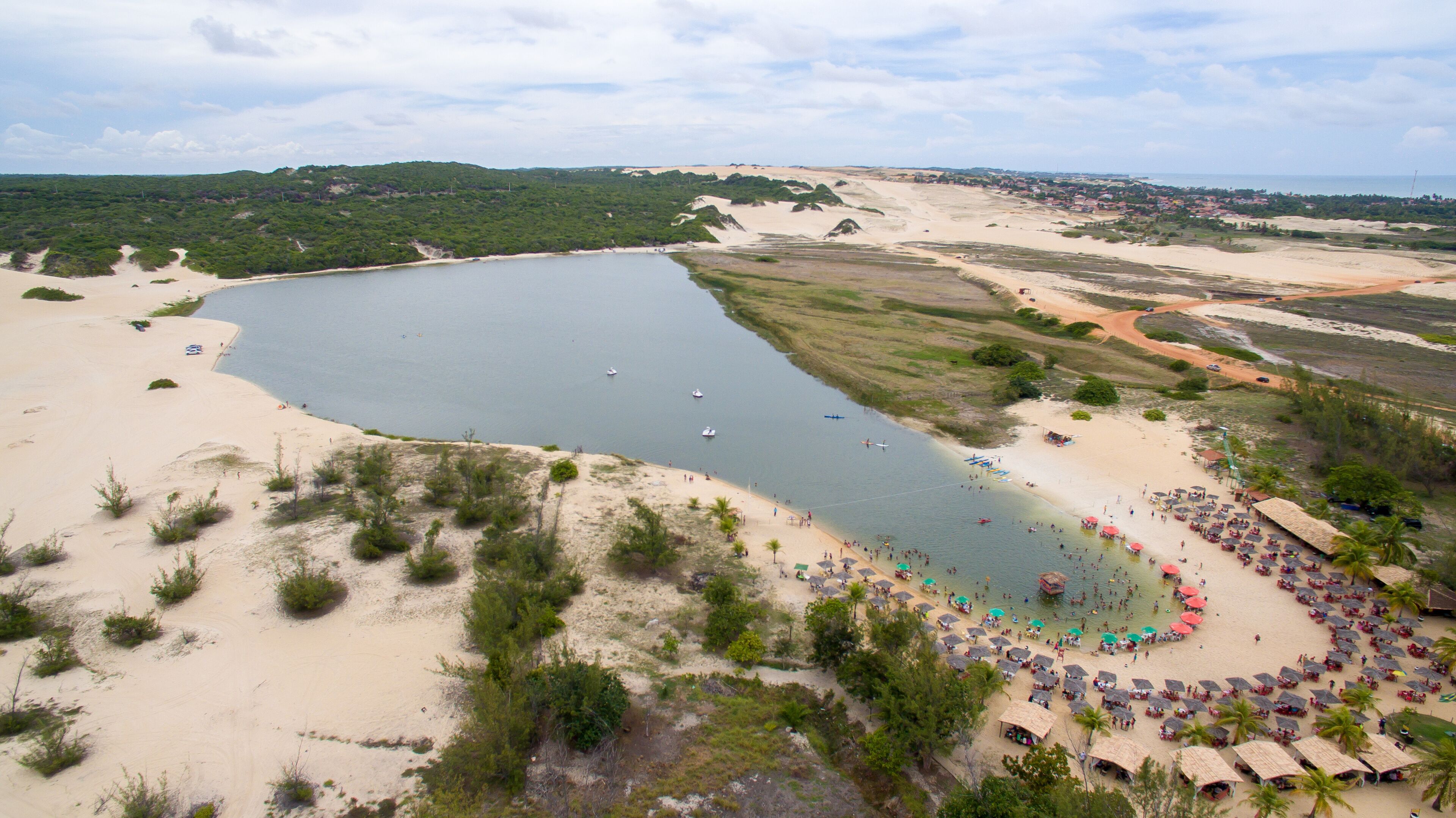 A coastal landscape with a large body of water, sandy beaches, and a small town in the distance.