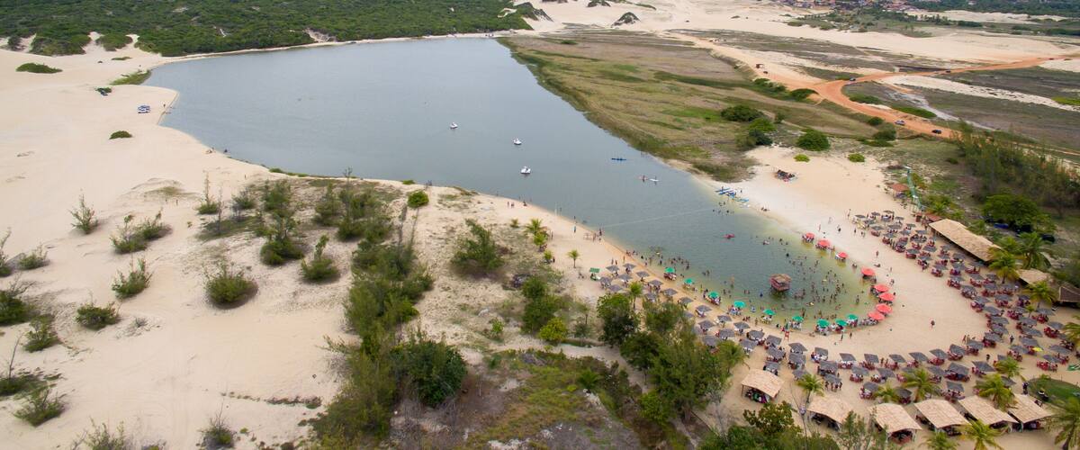 A coastal landscape with a large body of water, sandy beaches, and a small town in the distance.