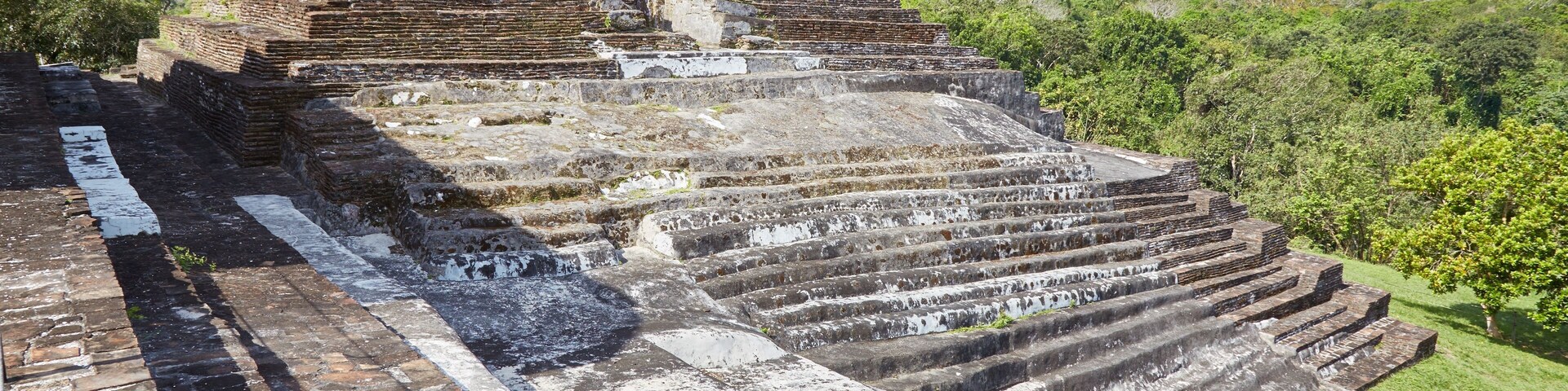 Ancient stepped structures with a stone staircase leading up to a ruin.