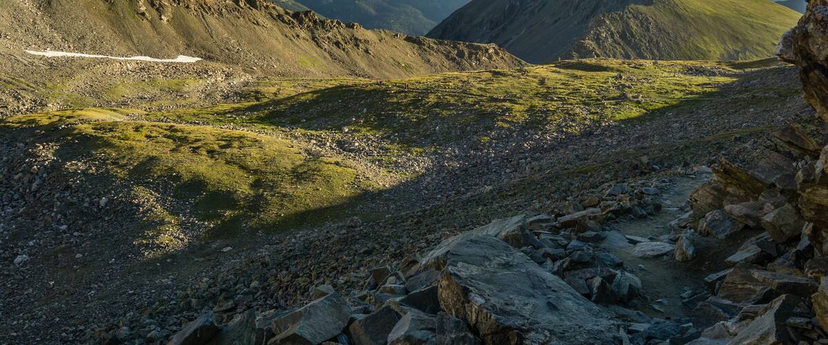 A mountainous landscape with rocky terrain and patches of grass.