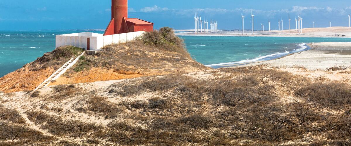 Beach lighthouse and distant wind farm, Fortim, Ceara, Brazil
