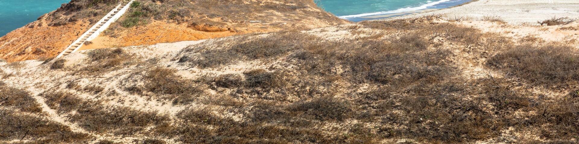 Beach lighthouse and distant wind farm, Fortim, Ceara, Brazil