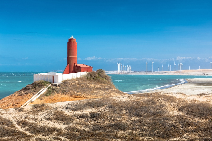 Beach lighthouse and distant wind farm, Fortim, Ceara, Brazil