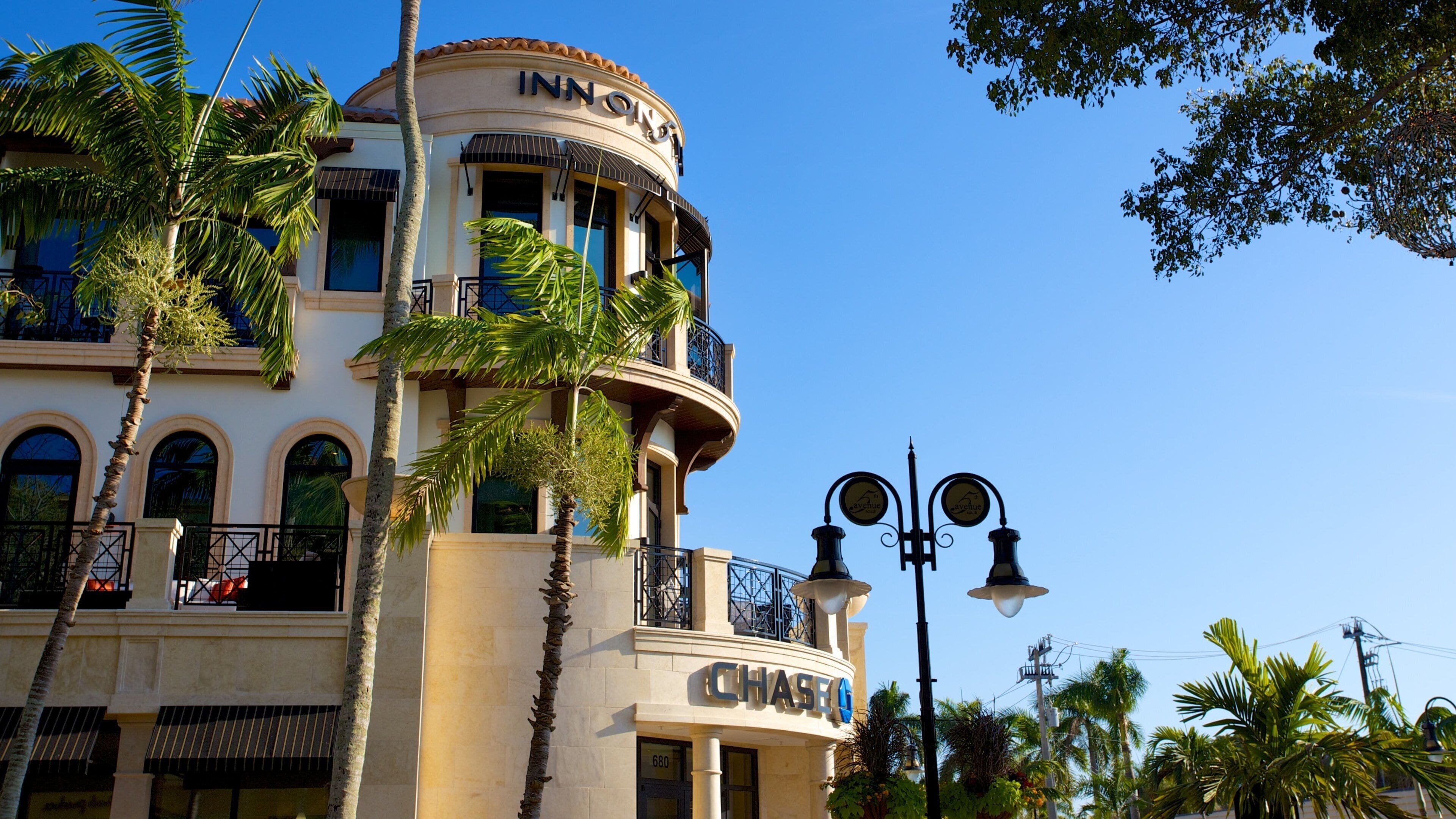 A building with a 'Chase' sign, palm trees, and a clear blue sky.