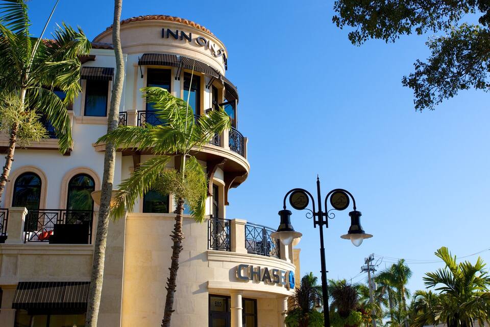 Un edificio con il cartello 'Chase', palme e un cielo azzurro limpido.