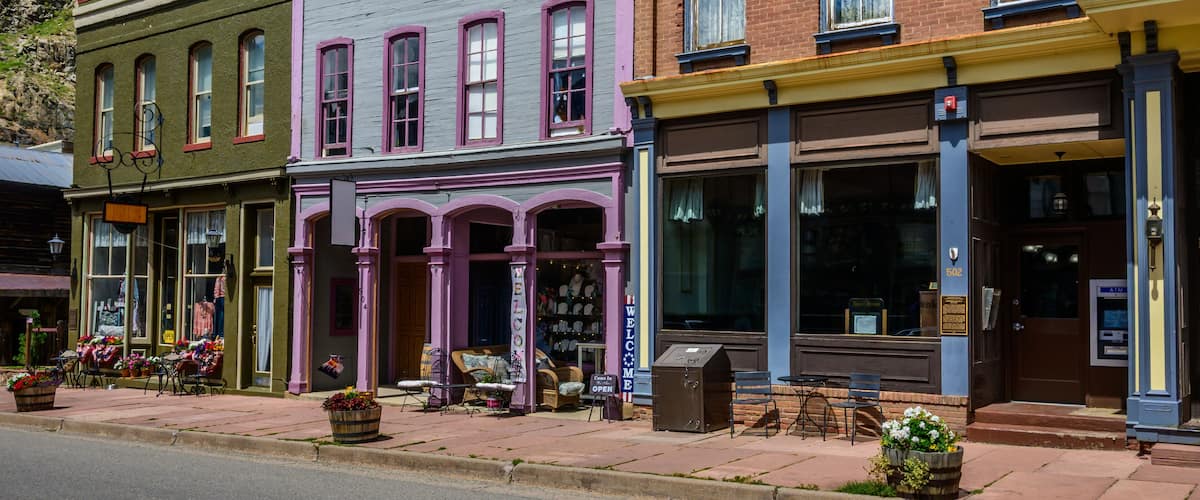 A row of colorful historic buildings with a mountain backdrop.