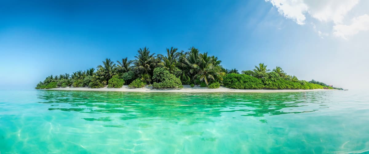 A tropical island surrounded by turquoise waters.