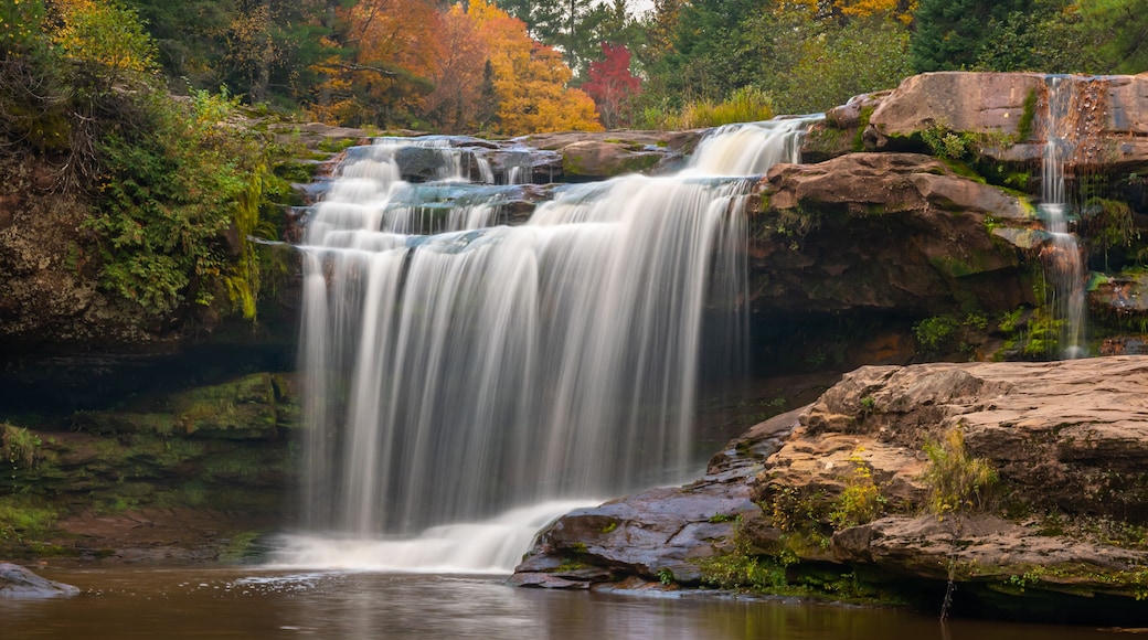 O Kun-de-Kun Falls nestled against an autumn-colored forest, on the Baltimore River, near Bruce Crossing, Michigan.