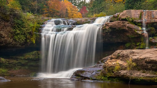 O Kun-de-Kun Falls nestled against an autumn-colored forest, on the Baltimore River, near Bruce Crossing, Michigan.
