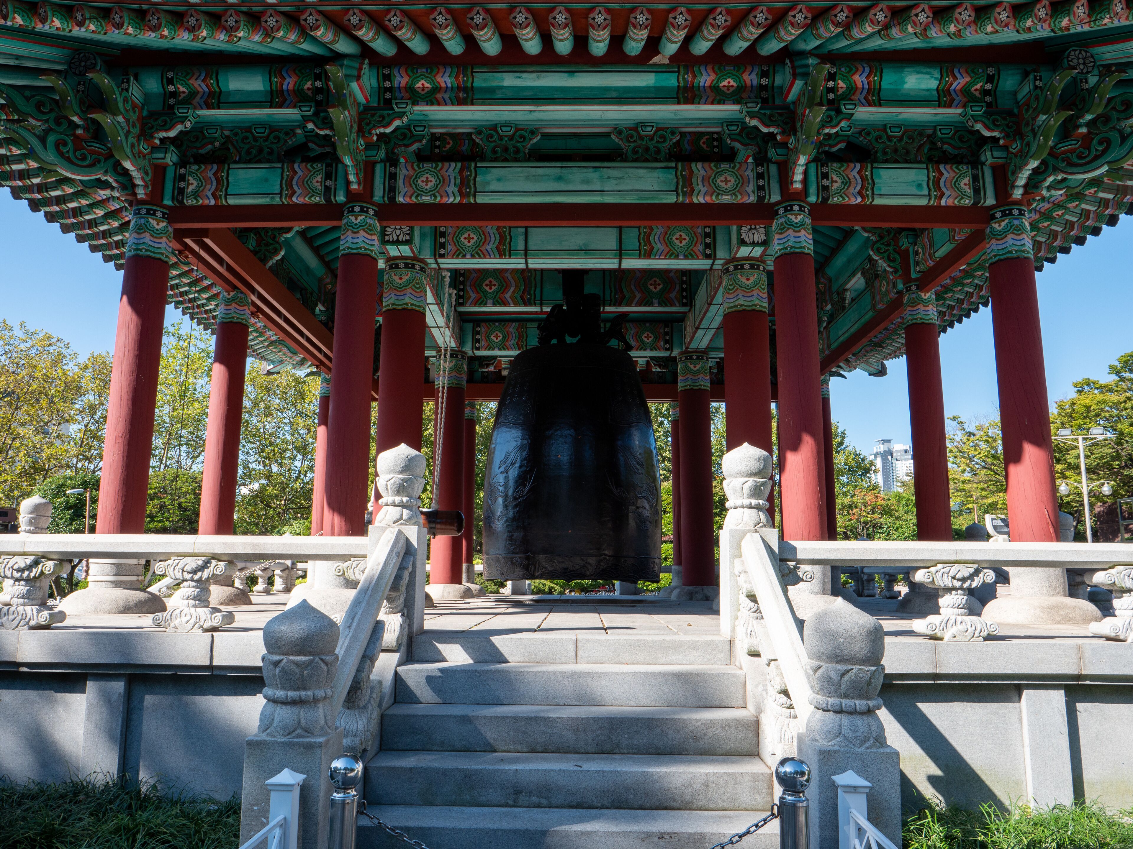 A traditional Korean pavilion with red pillars and ornate roof decorations.