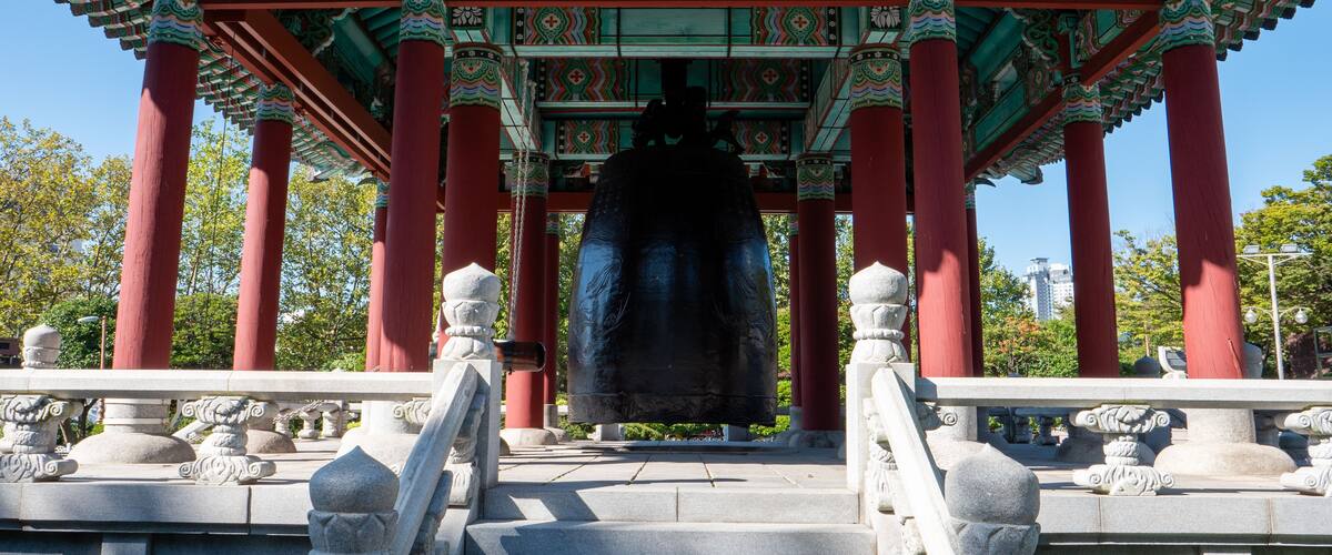 A traditional Korean pavilion with red pillars and ornate roof decorations.