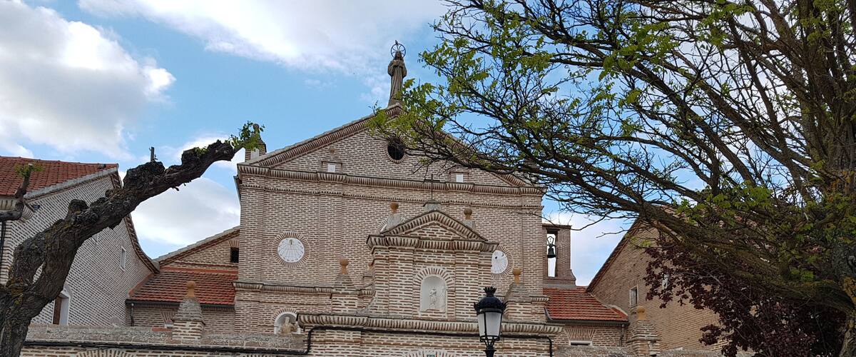 A historic church with a brick facade, arched windows, and a bell tower.
