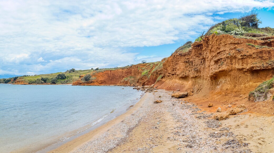 Duboka Draga Beach, Vir Island, Croatia: Red cliffs meet the sea under a cloudy sky