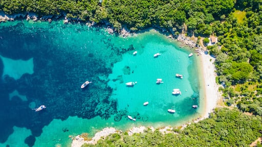An aerial view of the Blue Lagoon at Plaža Krušćica and Tarej Beach on the island of Cres, showcasing their fantastic turquoise waters and surrounding islands. Boats dot the serene lagoon