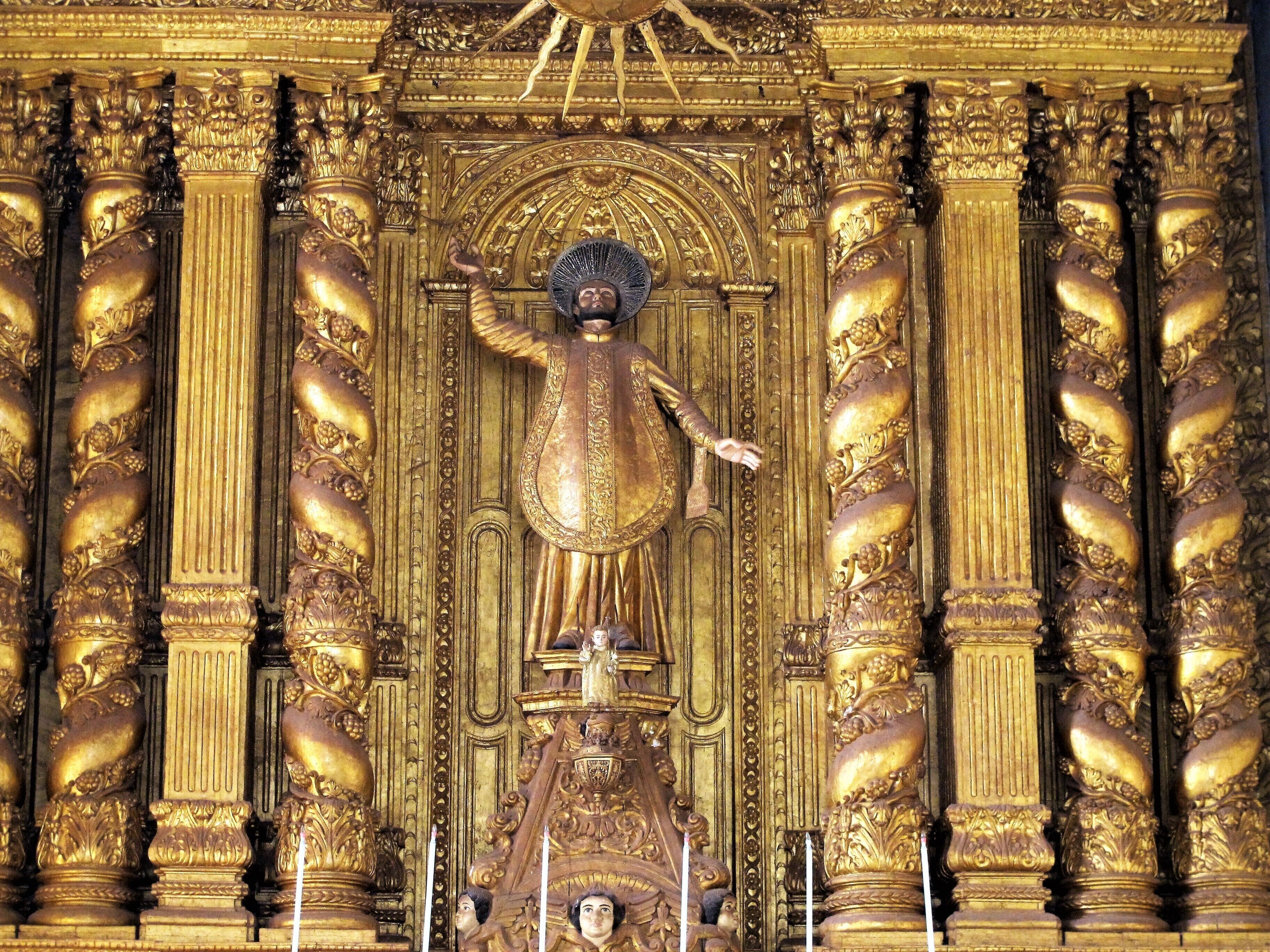 A golden statue with intricate carvings and columns.