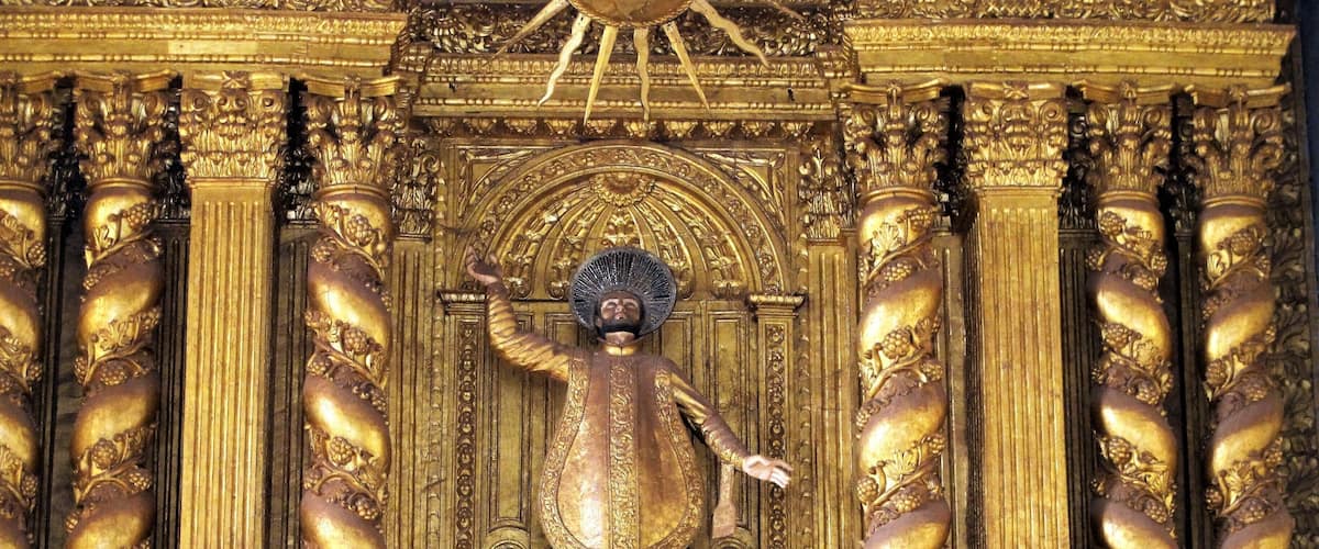 A golden statue with intricate carvings and columns.