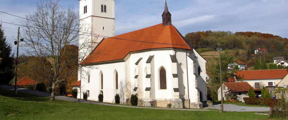 A church with a red-tiled roof and a bell tower with multiple domes.
