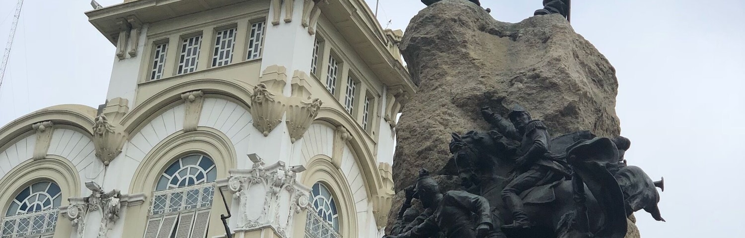 Eine Statue eines Soldaten auf einem Sockel, im Hintergrund ein Gebäude.